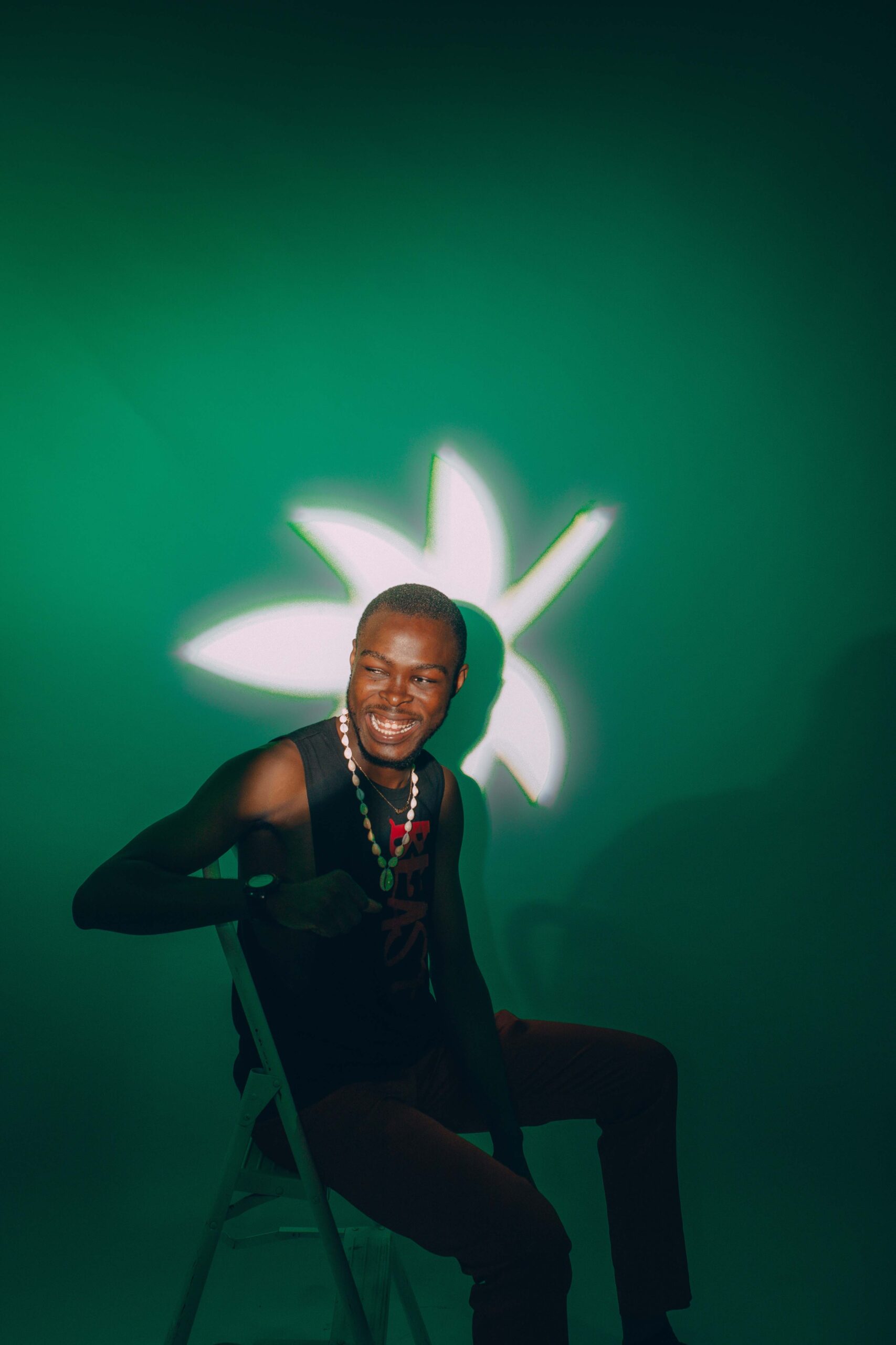 Smiling man on chair with green light.