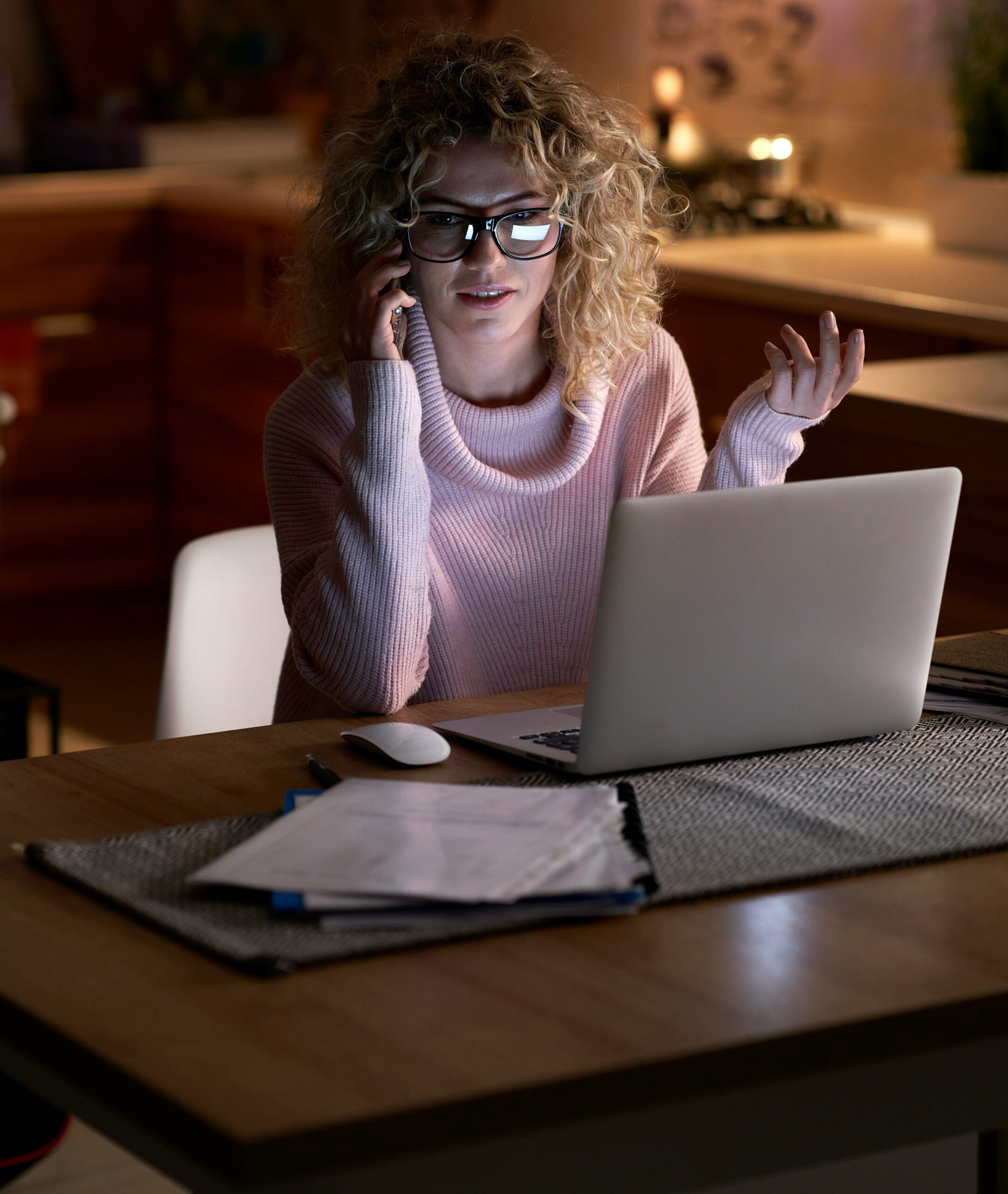Woman with glasses working late on laptop